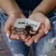 A hand holding some loose change, and a sign reading make a change